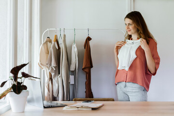 Businesswoman showing crop top during video call through laptop at home