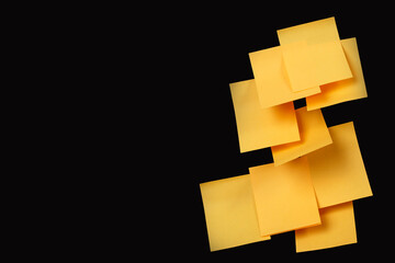 Set of yellow folded note paper sheets on black background