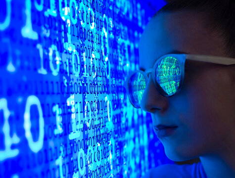 Female computer hacker with binary code reflection on eyeglasses
