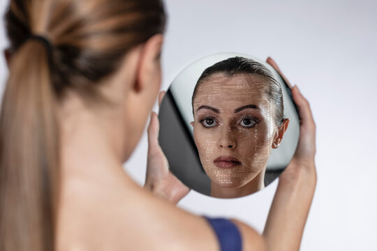 Female robot looking at mirror reflection over white background
