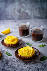 Chocolate tartlets with chocolate cream filling and mango fruit in the form of roses