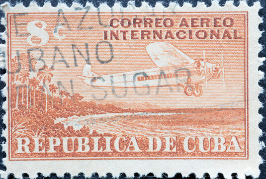 UBA - CIRCA 1960: A post stamp printed in Cuba showing an aircraft with three propellers flying over the country's coastline of cuba.