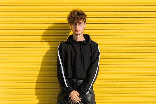 Young man in front of yellow shutter