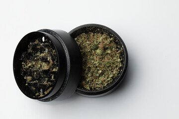 Grinder with Crushed buds of marijuana weed cannabis isolated, medical marijuana