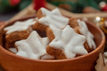 Star-shaped Christmas cookies with white icing on a black New Year's Eve background with Christmas tree branches 