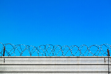 Way to freedom. Freedom blue sky behind the barbed wire fence