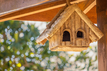 small wooden house for birds - sunny blurred background. Copy space.