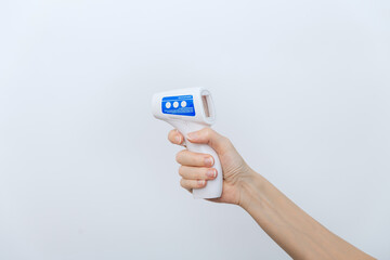 Temperature measurement gun in doctor hands. Close-up shot of doctor wearing protective surgical mask ready to use infrared isometric thermometer gun to check body temperature for virus symptoms