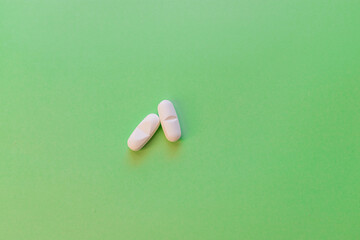 White tablets on a green background. Treatment. Medical background.
