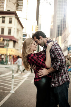 Young couple embracing on street in city