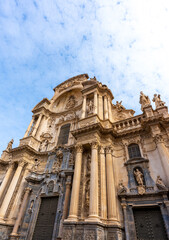 Fototapeta na wymiar Low angle view of Cathedral Church of Saint Mary in Murcia on a cloudy day
