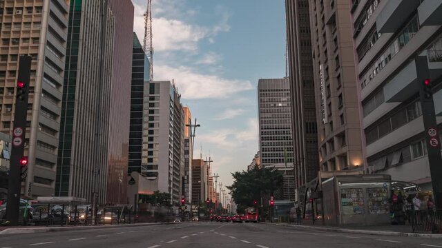 motion timelapse da avenida Paulista em S&atilde;o Paulo, durante um por do sol lindo, sunset com poucas nuvens e muito tr&acirc;nsito zoom out
