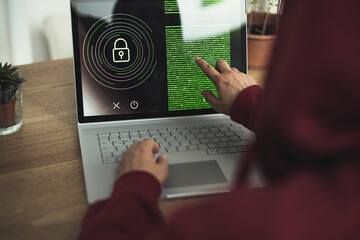 Woman reading data on laptop at home