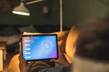 Woman checking home automation system through digital tablet at home