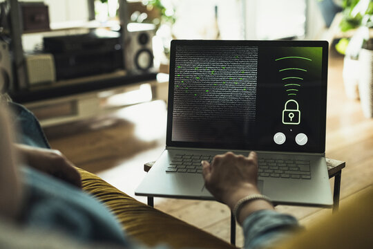 Woman accessing security system on laptop at home