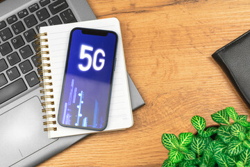 Modern mobile phone with 5G network, hologram background. Business desktop. Concept photo of high speed internet, new generation of networks
