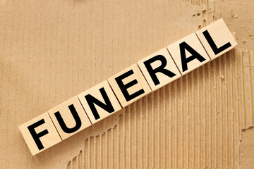 FUNERAL. text on five wooden blocks. cubes on torn paper