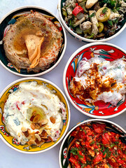Turkish or Mediterranean appetizers. Turkish festive food. Collection of traditional mezes or appetizers on a white tablecloth. View from above 
