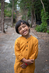 a boy smiling and folding his arms