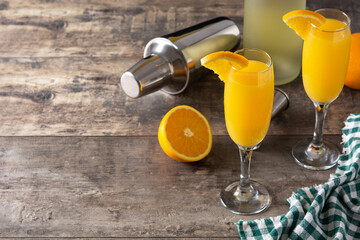 Orange mimosa cocktail on wooden table.Copy space