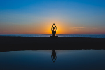 Silhouette of a woman meditating on the beach at sunset, outdoors.
  style silhouette
