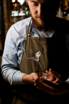 Man Bartender Neatly Holding An Empty Wine Goblet Glass In His Hands