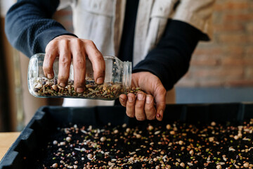 Man removing seeds from glass jar at workshop