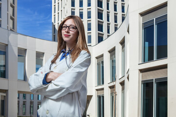 young female doctor outside a modern building that could be a hospital