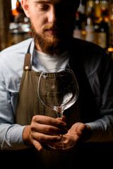 beautiful close-up view of transparent wine goblet in male hands.