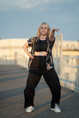 Girl dancing on the bridge at sunset