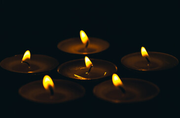 Burning wax candle on a black background