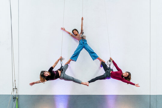Passionate female dancers practicing while hanging together on rope