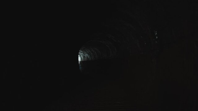 Spooky Interior of Old Railway Tunnel With Light in the Distance