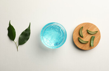 Flat lay composition with blue cosmetic gel and aloe on white background