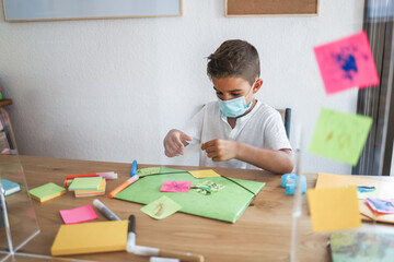 Kid painting in preschool classroom wearing safety mask - Focus on child face
