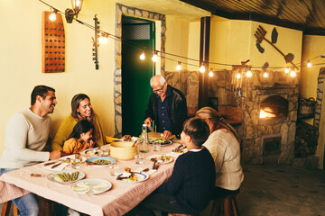Happy latin family cooking together during dinner time at home - Soft focus on grandfather face