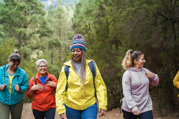Multiracial women having fun during trekking day in to the wood - Focus on african female face