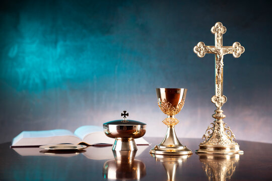 Religion concept. Catholic symbols composition: monstrance, The Cross, Holy Bible, rosary and golden chalice. 
