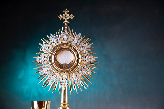 Religion concept. Catholic symbols composition: monstrance, The Cross, Holy Bible, rosary and golden chalice. 