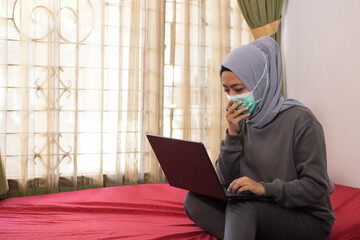 Asian women in hijabs with masks are coughing when working from home