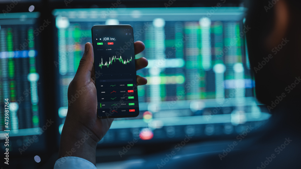 Poster financial analyst using smartphone with real-time stocks, commodities and market charts. working on 