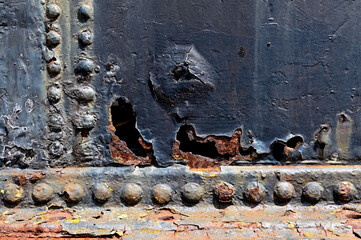 Close up of rusted metal plates on a stno people,eam engine. No people.