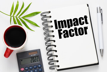 Impact factor words written in an office notebook.