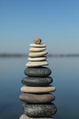 Fototapeta na wymiar Stack of stones near sea on sunny day. Harmony and balance concept