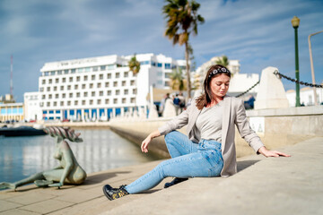 Fototapeta na wymiar Portrait of young woman sitting by the marina