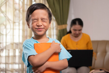 cute asian boy accompanying his mother working