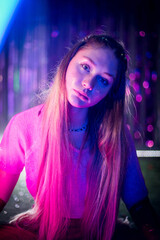 Fototapeta premium Cinematic night portrait of girl and neon lights. Fashion. Woman in Colorful neon light. girl in disco, makeup dance. Party disco neon nightclub vibes. creative art neon pink blue light.
