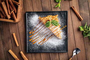 Sweet fresh honey cake slice with powdered sugar and mint