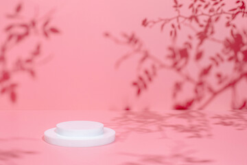 Abstract minimal nature scene - empty stage and circle podium on pink background and soft shadows of rose flowers and leaves. Pedestal for cosmetic product and packaging mockups display presentation