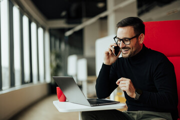 Cheerful adult executive, conntacting his client about a product, on the phone.